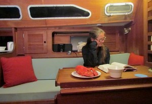 reading at the salon table of a sailboat