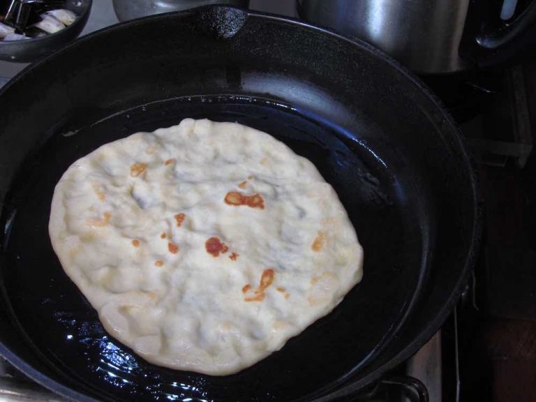 naan cooking in cast iron skillet