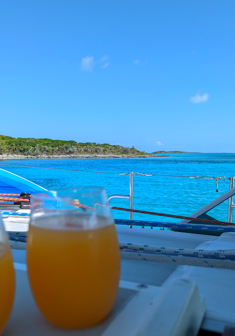 two glasses of rum punch in front of turquoise water in The Bahamas.