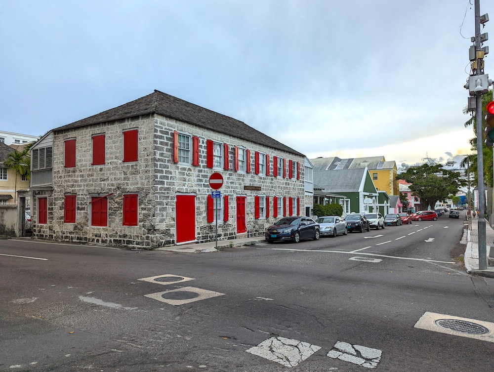 Old stone building with red shutters downtown Nassau, Bahamas.

